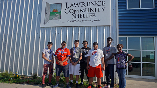 Group of students with Jomella Watson-Thompson in front of the Lawrence Community Shelter.